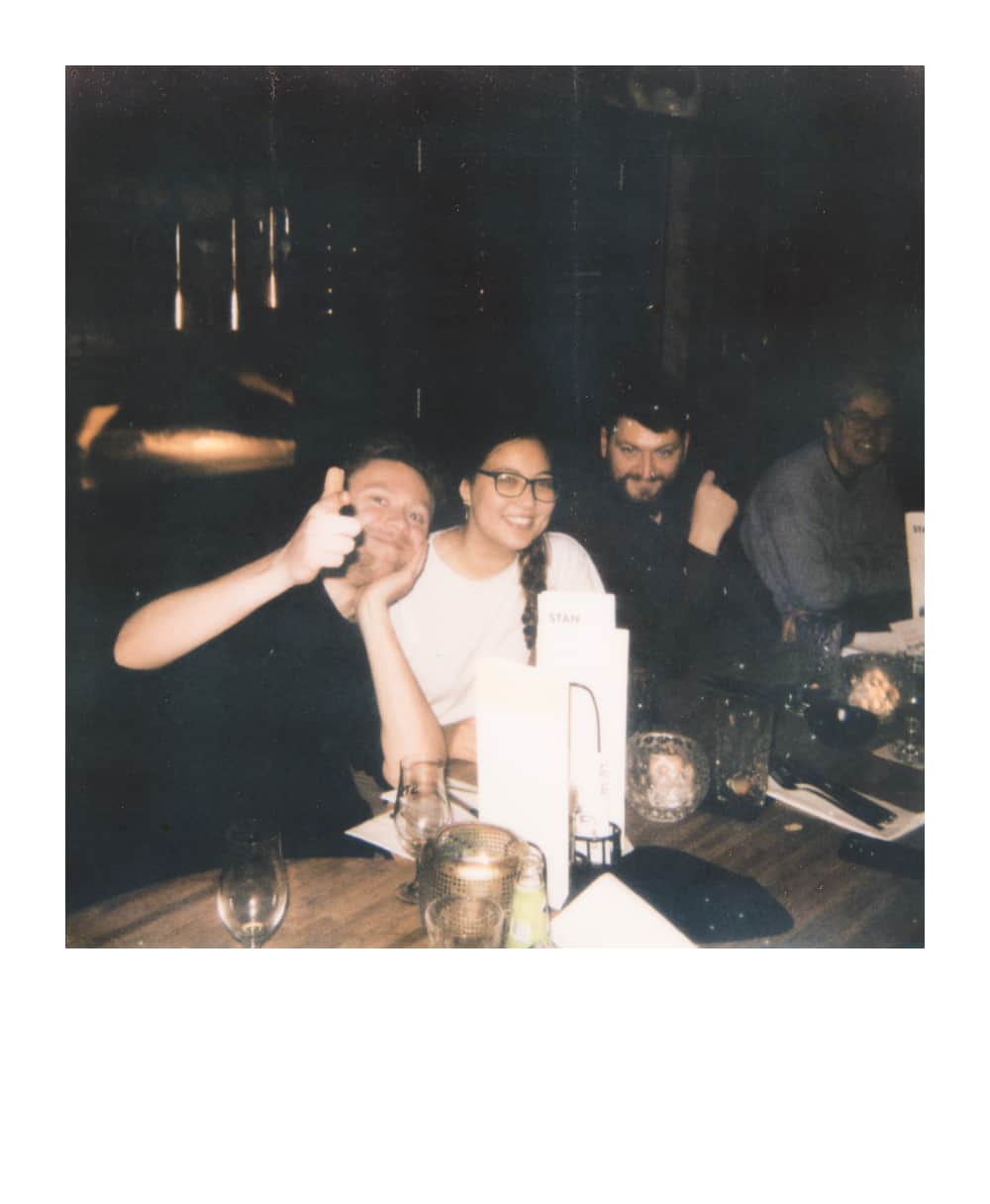 Four friends gathered around a dimly lit table at a D&D event
