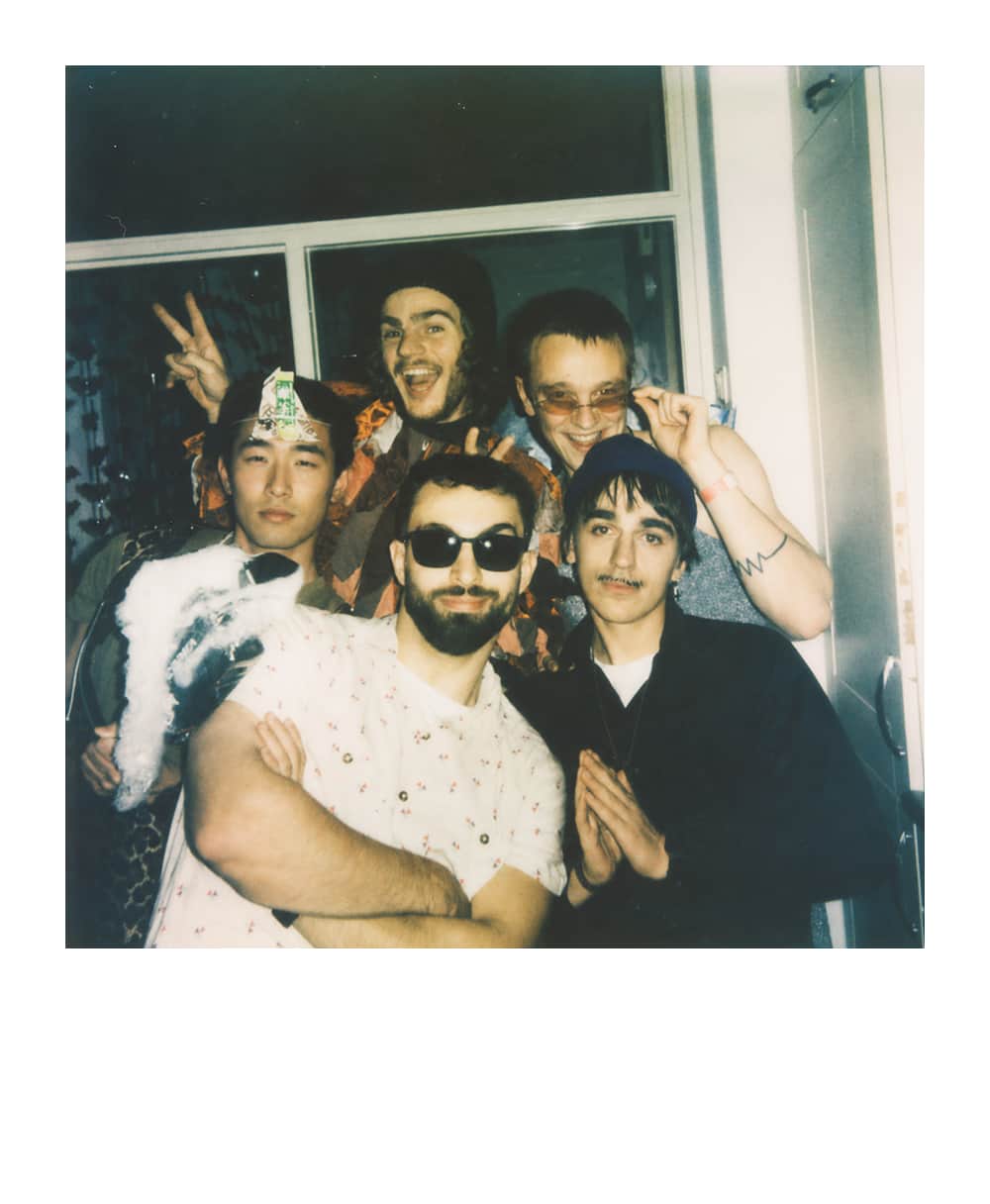 Five costumed friends posing together at a lively TTRPG costume party