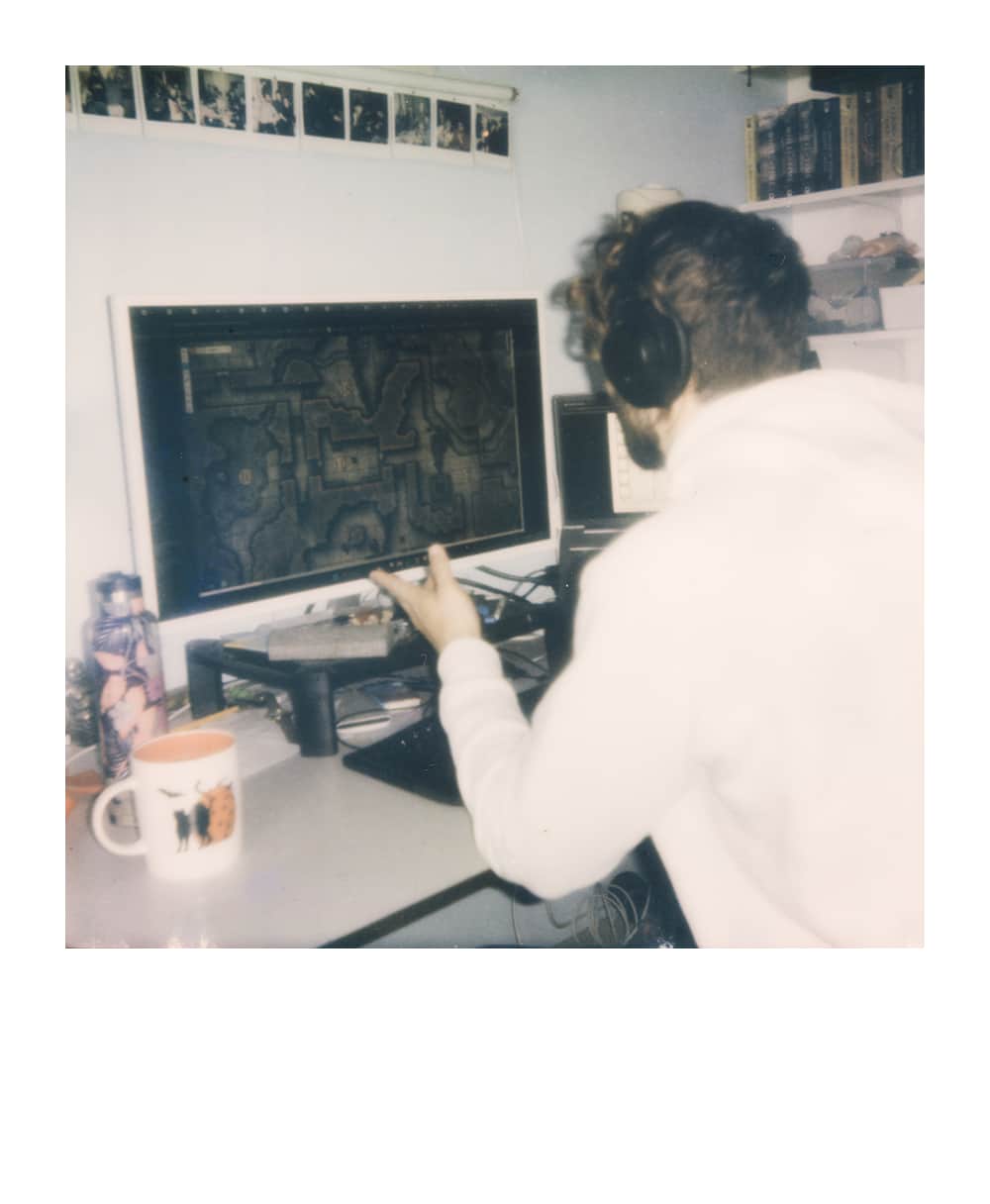 Player wearing headphones at a computer displaying a fantasy map for an online tabletop RPG session.